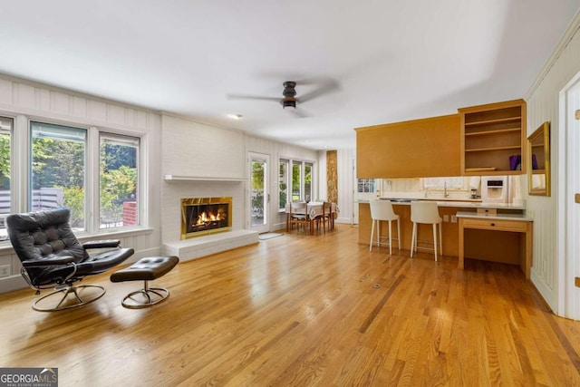 kitchen featuring a wealth of natural light, a breakfast bar, ceiling fan, and light wood-type flooring