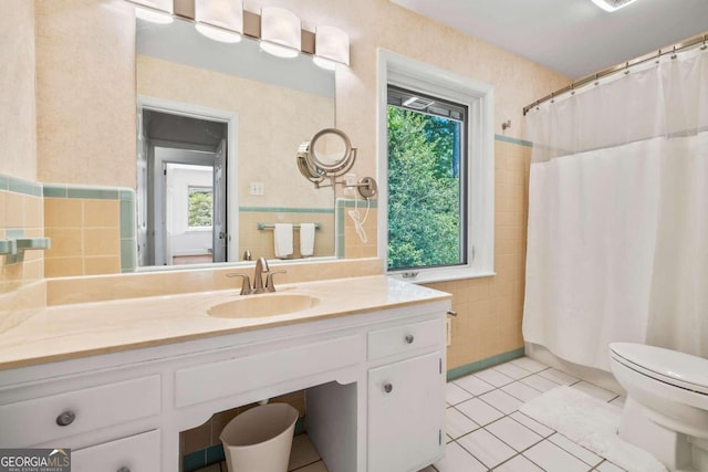 bathroom featuring toilet, plenty of natural light, tile walls, and tile patterned flooring