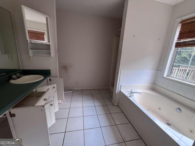 bathroom with tile patterned flooring, vanity, toilet, and a tub to relax in