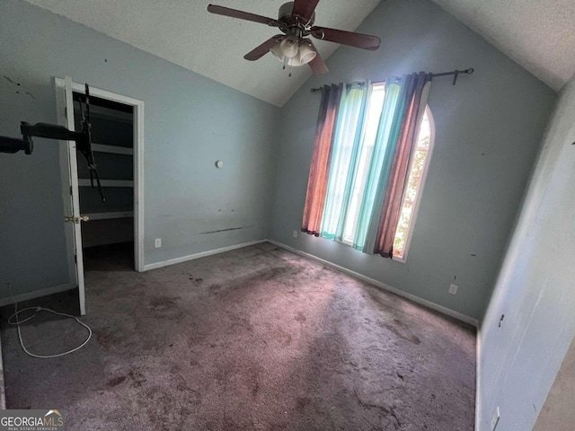 unfurnished bedroom featuring ceiling fan, multiple windows, a textured ceiling, and vaulted ceiling