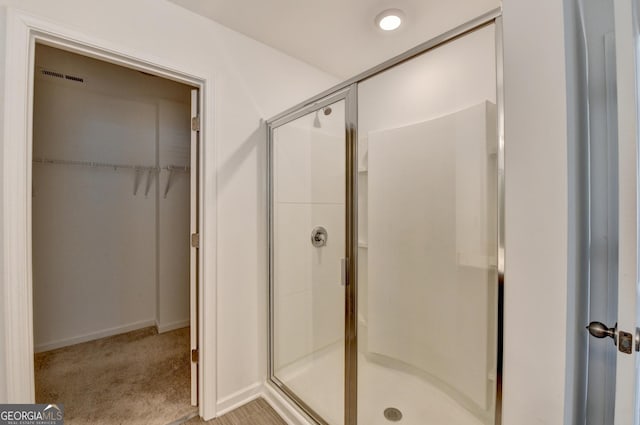 bathroom with a shower with door