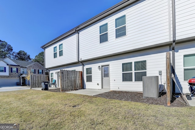 rear view of house with a lawn, a patio, and central AC