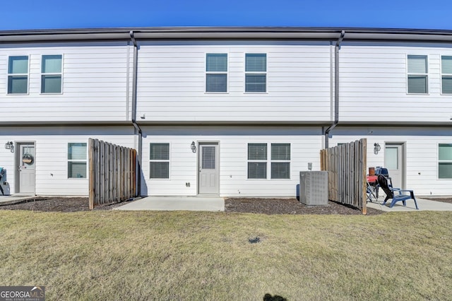 back of property with central air condition unit, a patio area, and a lawn