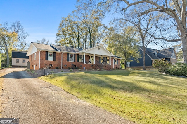 ranch-style home featuring covered porch and a front yard