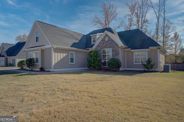 view of front of home with central AC and a front lawn