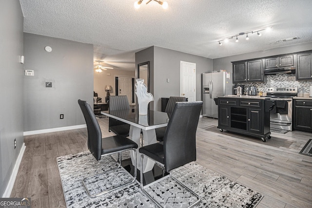 dining area featuring ceiling fan, light hardwood / wood-style flooring, and a textured ceiling