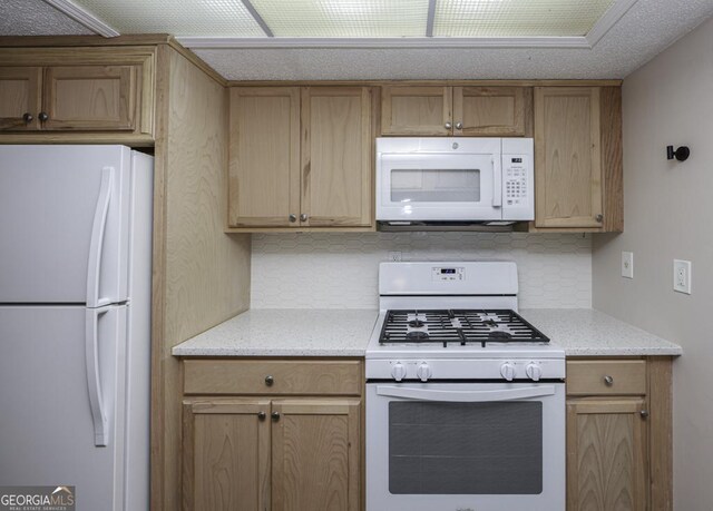 kitchen with light brown cabinets, white appliances, and backsplash