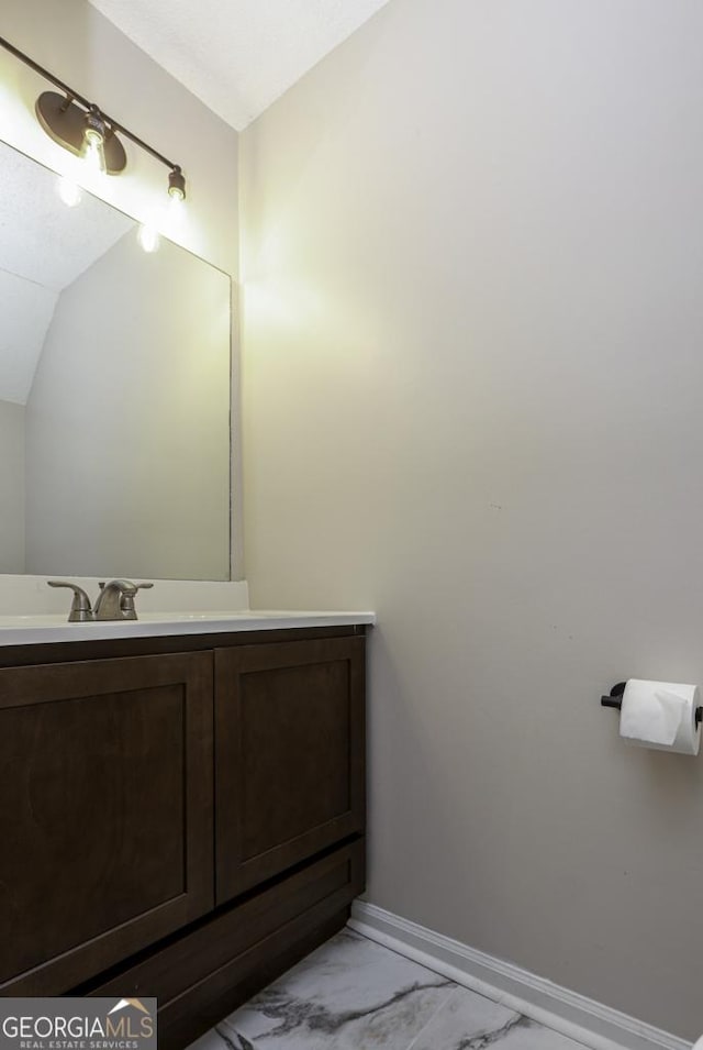 bathroom featuring marble finish floor, vanity, and baseboards