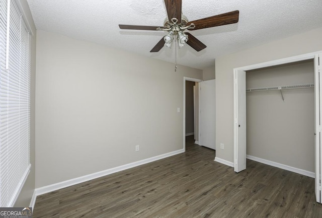 unfurnished bedroom featuring ceiling fan, dark hardwood / wood-style flooring, a textured ceiling, and a closet