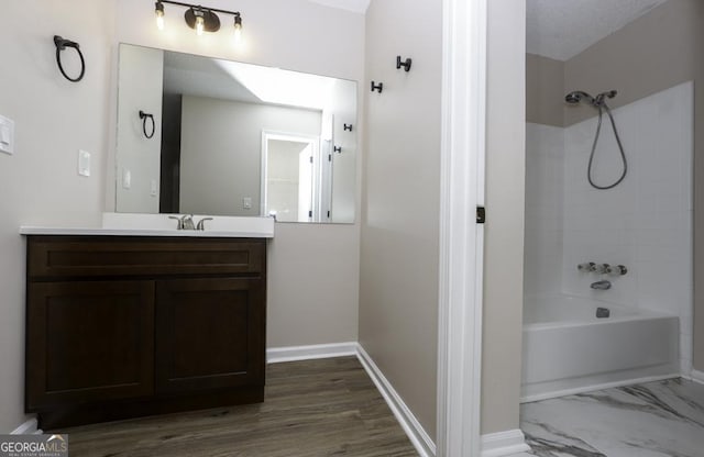 full bathroom with marble finish floor, baseboards, vanity, and shower / tub combination