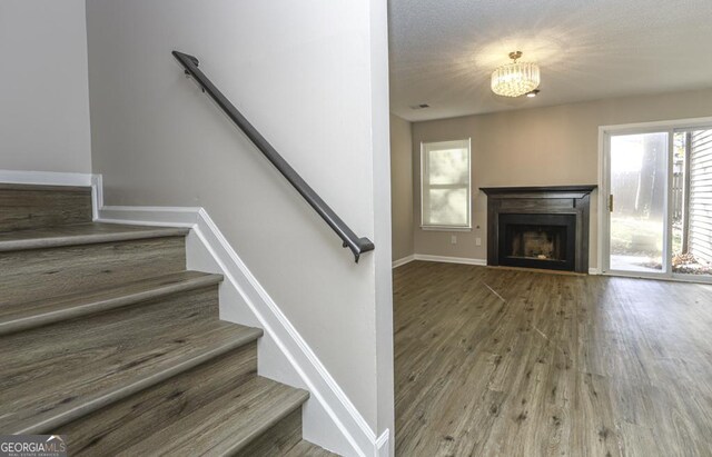 stairway with a chandelier and wood-type flooring