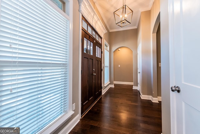 entrance foyer with crown molding, dark hardwood / wood-style floors, and a chandelier