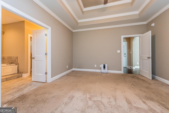 carpeted spare room with crown molding and a tray ceiling