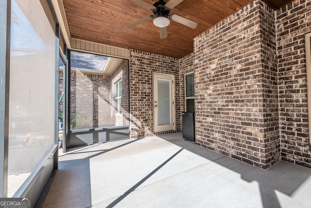 unfurnished sunroom featuring wooden ceiling and ceiling fan