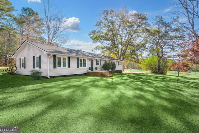 view of side of home with a wooden deck and a yard