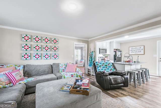 living room with wood-type flooring and ornamental molding