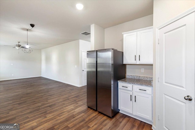 kitchen featuring light stone countertops, ceiling fan, dark hardwood / wood-style floors, white cabinetry, and stainless steel refrigerator