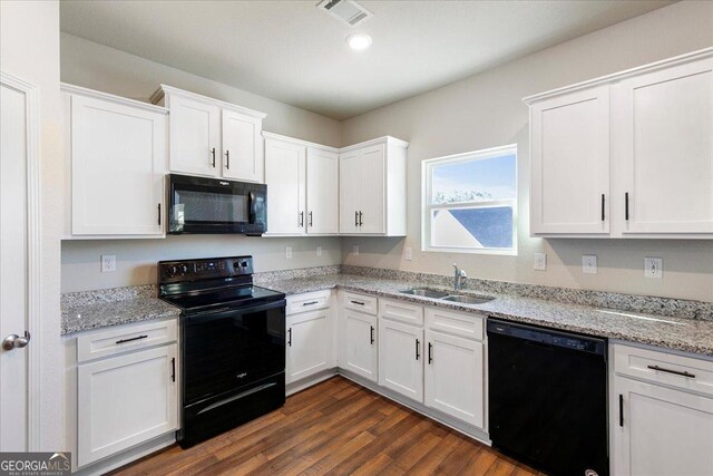 kitchen with light stone countertops, sink, black appliances, white cabinets, and dark hardwood / wood-style floors