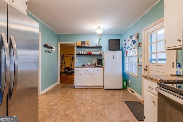 kitchen with light carpet, stainless steel appliances, white cabinetry, and ornamental molding