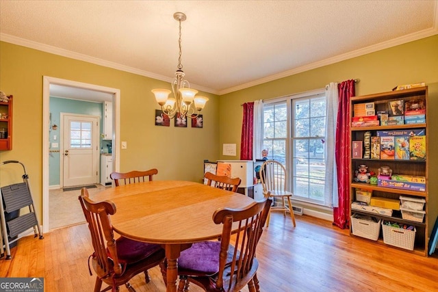 dining room with a textured ceiling, a notable chandelier, crown molding, and light hardwood / wood-style flooring