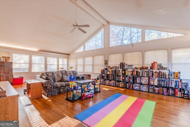 interior space featuring beamed ceiling, wood-type flooring, high vaulted ceiling, and ceiling fan