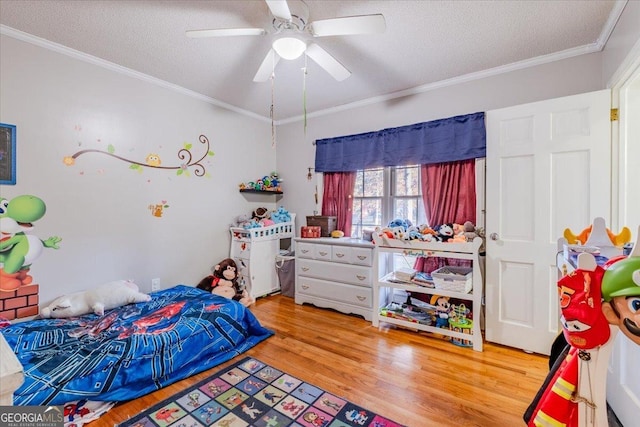 bedroom with hardwood / wood-style flooring, ceiling fan, ornamental molding, and a textured ceiling