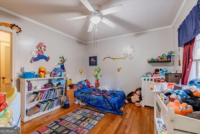 bedroom featuring a textured ceiling, ceiling fan, wood-type flooring, and ornamental molding