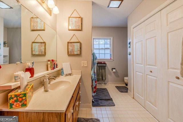 bathroom featuring tile patterned flooring, vanity, and toilet