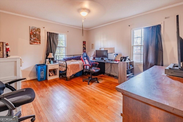 bedroom featuring a textured ceiling, light wood-type flooring, and ornamental molding