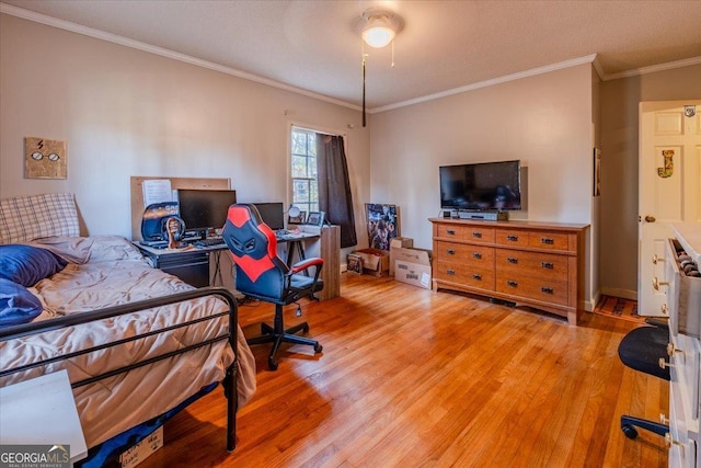 bedroom with light hardwood / wood-style floors, ceiling fan, and crown molding