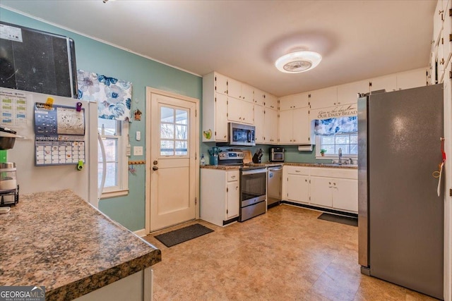 kitchen with white cabinetry, stainless steel appliances, and a wealth of natural light