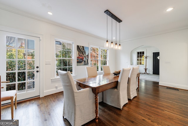 dining room with ornamental molding and dark wood-type flooring