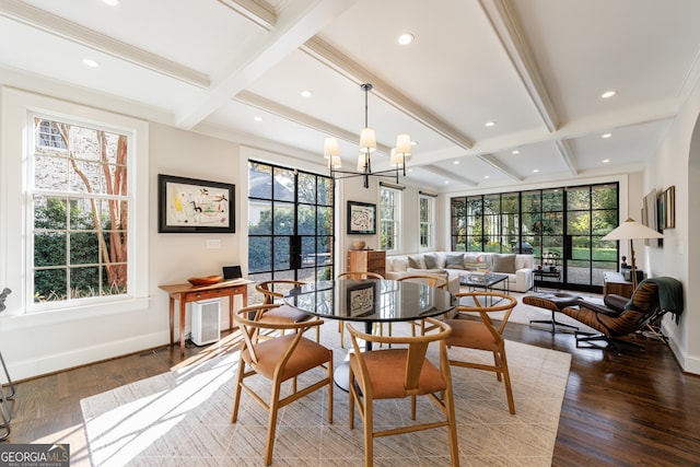 dining space featuring beamed ceiling, wood-type flooring, an inviting chandelier, and crown molding