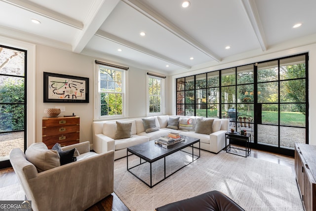 living room featuring beam ceiling, light hardwood / wood-style flooring, and a healthy amount of sunlight