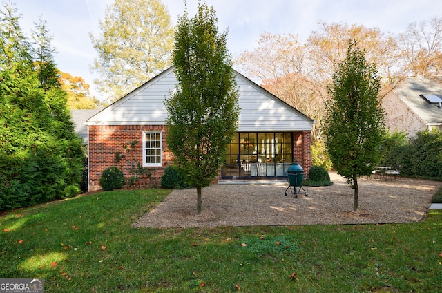 back of house with a yard and a patio