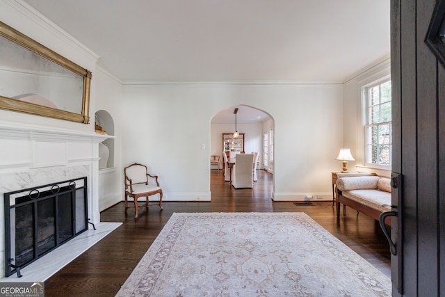 living room featuring crown molding, a fireplace, and dark hardwood / wood-style floors