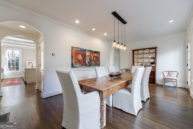 dining area with ornamental molding and dark wood-type flooring