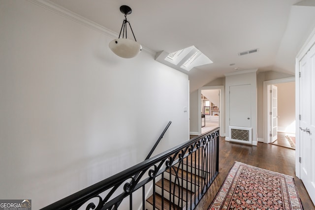 hallway with ornamental molding, dark wood-type flooring, and vaulted ceiling