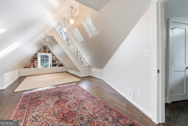 additional living space with dark wood-type flooring and vaulted ceiling