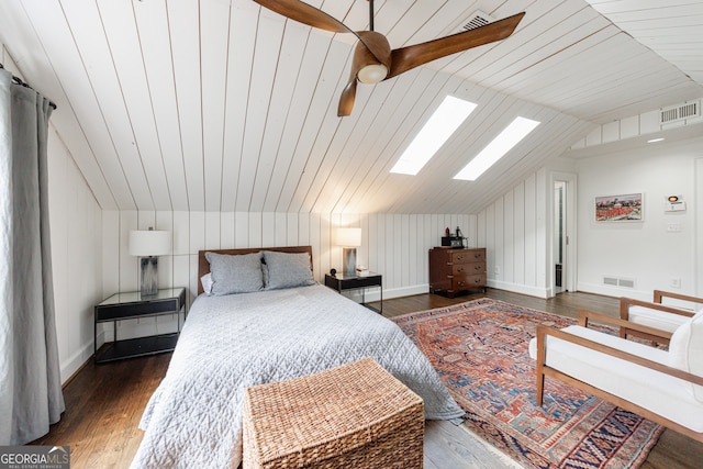 bedroom featuring vaulted ceiling with skylight, dark hardwood / wood-style floors, ceiling fan, and wooden ceiling