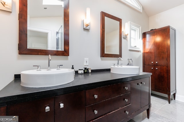 bathroom featuring tile patterned floors, vanity, and lofted ceiling