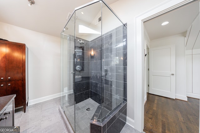 bathroom with hardwood / wood-style floors, vanity, a shower with door, and crown molding