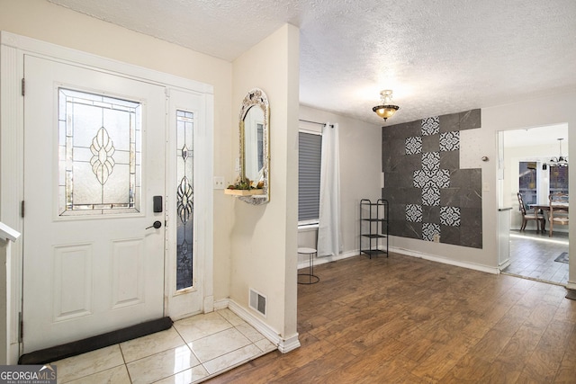 foyer entrance featuring a textured ceiling and hardwood / wood-style flooring