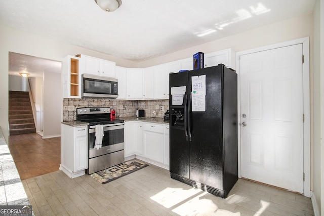 kitchen with backsplash, white cabinetry, stainless steel appliances, and light wood-type flooring