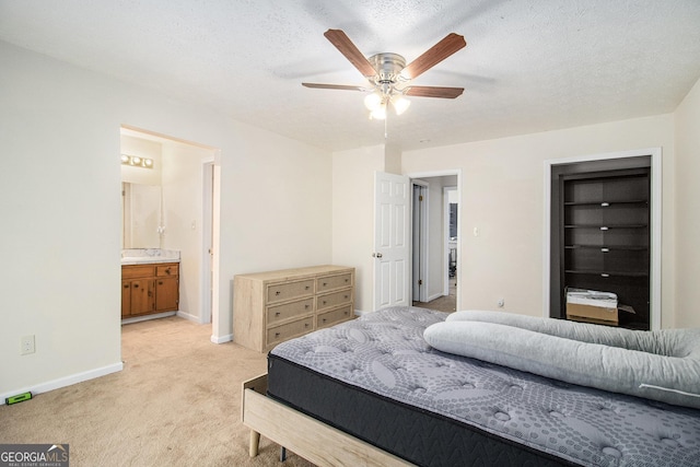 carpeted bedroom featuring a textured ceiling, ceiling fan, and ensuite bathroom