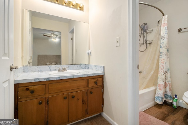 bathroom with hardwood / wood-style flooring, ceiling fan, vanity, and shower / tub combo