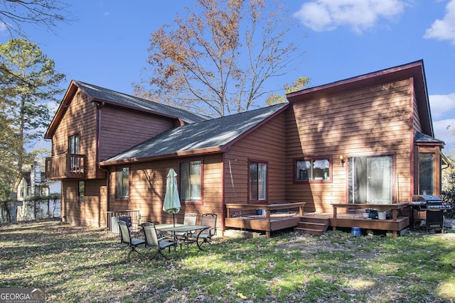 rear view of house featuring a yard and a wooden deck