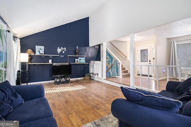 living room featuring a textured ceiling, hardwood / wood-style flooring, and lofted ceiling