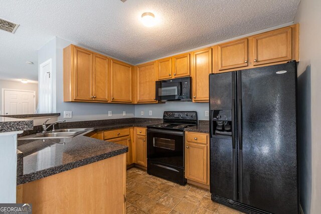 kitchen featuring kitchen peninsula, sink, black appliances, and a textured ceiling