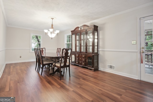 dining room with dark hardwood / wood-style floors, ornamental molding, and a textured ceiling